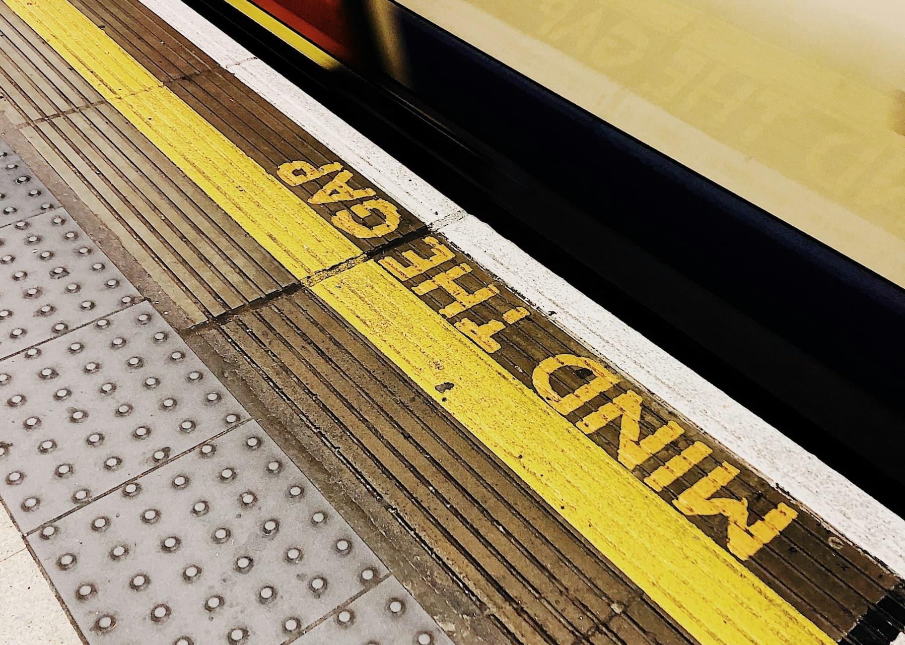A photo of the London Underground floor that says 'MIND THE GAP'.